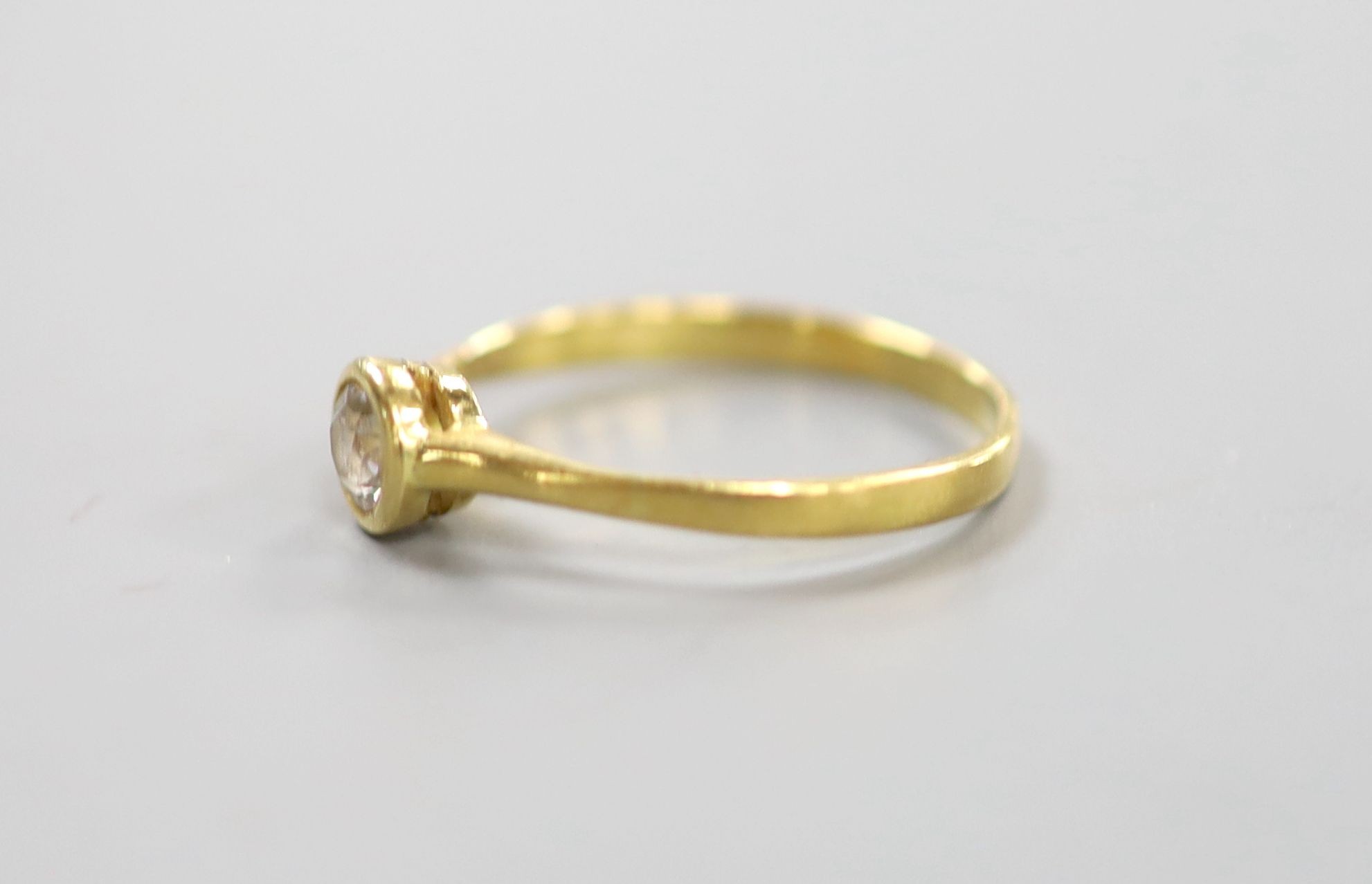 A yellow metal and collet set solitaire diamond ring, size P, gross weight 1.9 grams